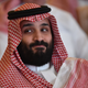 A man in a keffiyeh smirks at something off-camera.